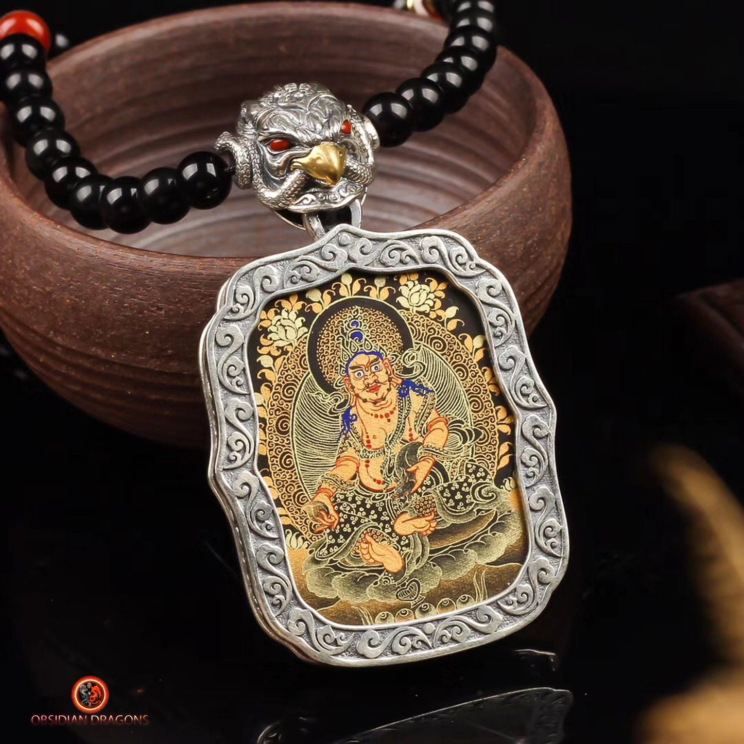 Pendentif Bouddha. Tangka artisanal Jambhala déité de la richesse tibétaine. Bélière Garuda - obsidian dragon