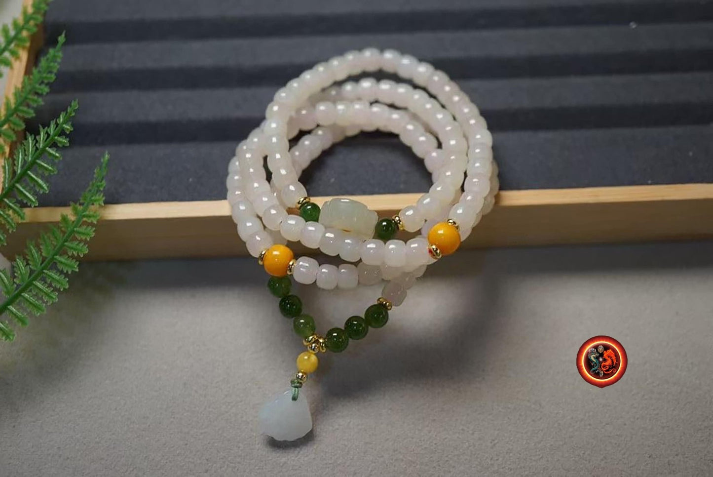 Mala, chapelet bouddhiste tibétain 108 perles de jade néphrite blanc tonneau de 5/5.8mm. Lotus en jade nephrite en finition Agates d'Alashan - obsidian dragon