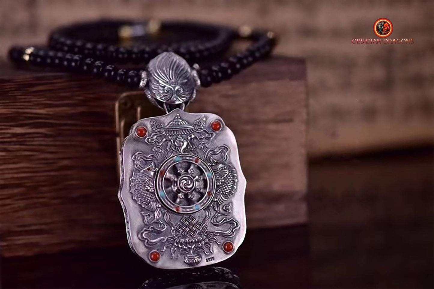 Pendentif bouddha Amitabha. Amulette de protection du bouddhisme vajrayana esoterique tibétain. représentation de Garuda sur la beliere. - obsidian dragon