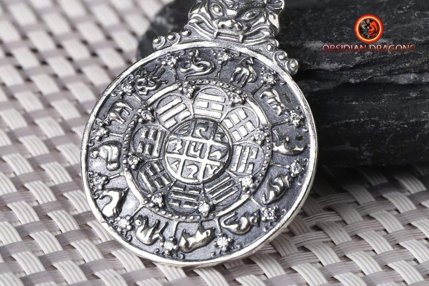 Amulette bouddhiste en argent 925 avec symbole du kartika bouddhiste au verso pour la protection tibétaine et le feng-shui, représentant la roue de la vie bouddhiste. - obsidian dragon