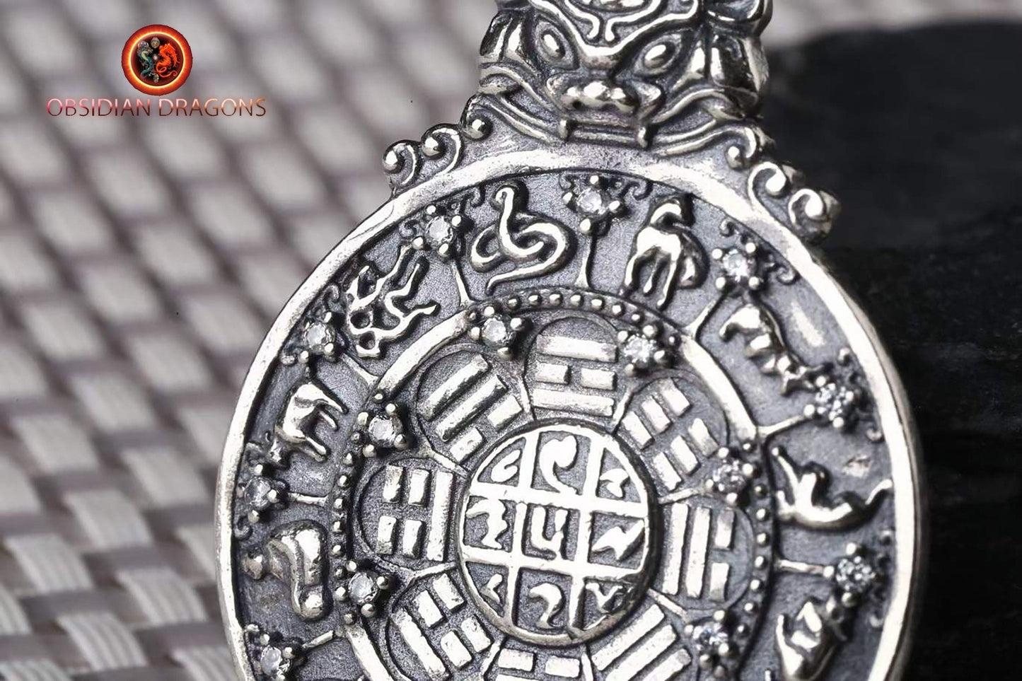 Amulette bouddhiste en argent 925 avec symbole du kartika bouddhiste au verso pour la protection tibétaine et le feng-shui, représentant la roue de la vie bouddhiste. - obsidian dragon