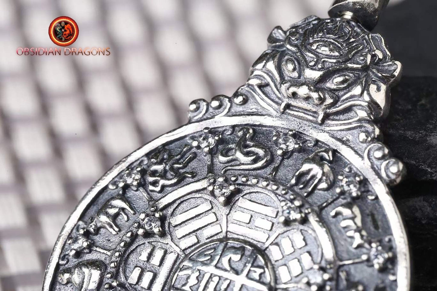 Amulette bouddhiste en argent 925 avec symbole du kartika bouddhiste au verso pour la protection tibétaine et le feng-shui, représentant la roue de la vie bouddhiste. - obsidian dragon