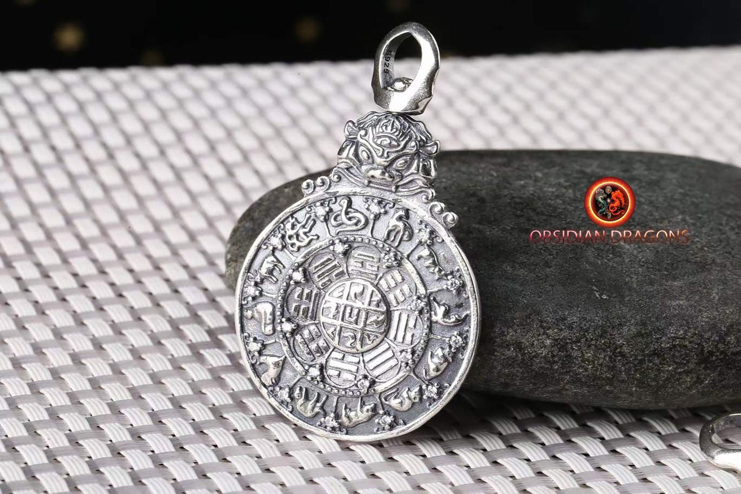 Amulette bouddhiste en argent 925 avec symbole du kartika bouddhiste au verso pour la protection tibétaine et le feng-shui, représentant la roue de la vie bouddhiste. - obsidian dragon