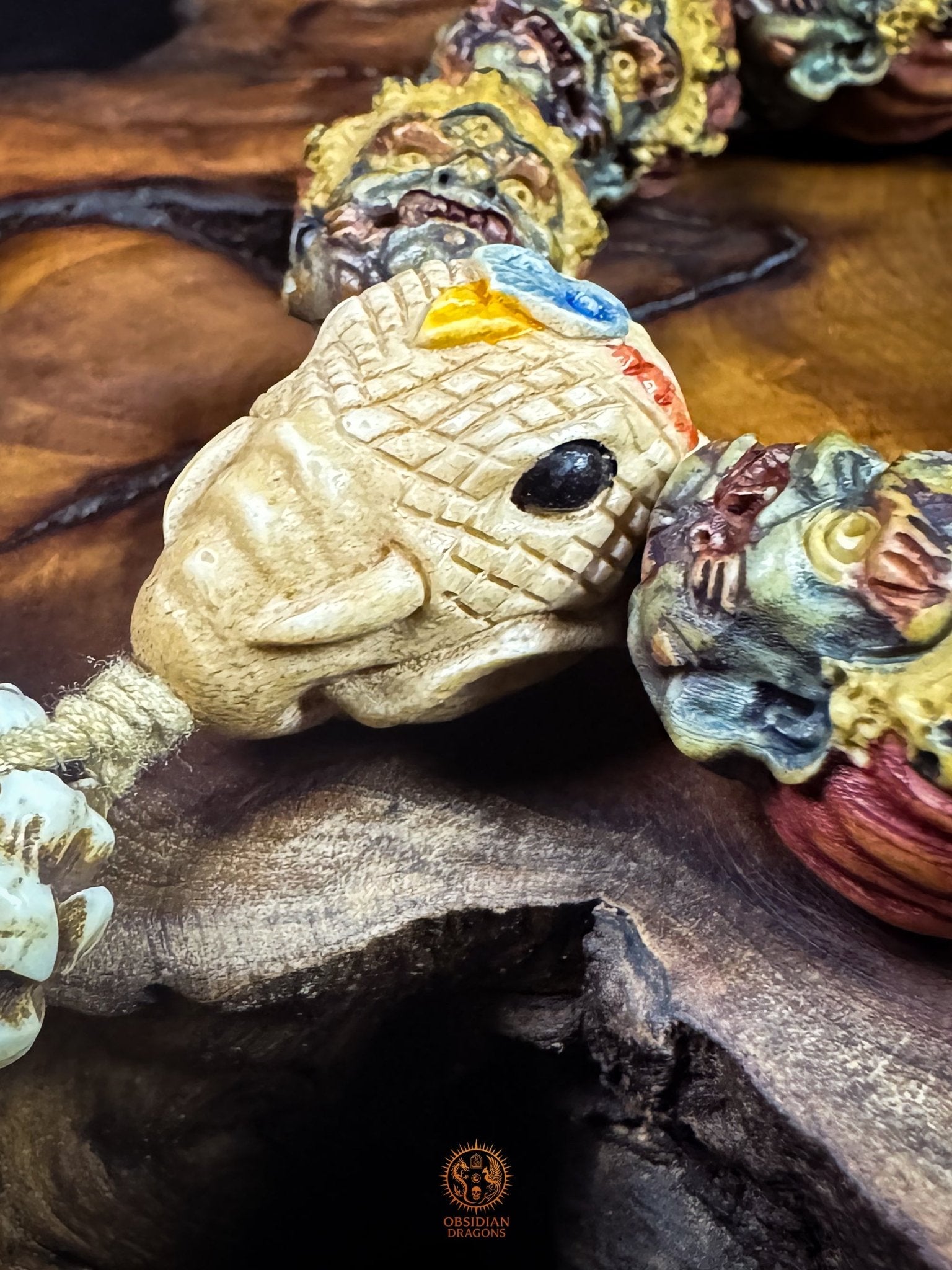 Profil sculpté de Ganesh Kangiten en bois de cerf avec trompe et défenses, entouré de perles Mahakala teintes artisanalement