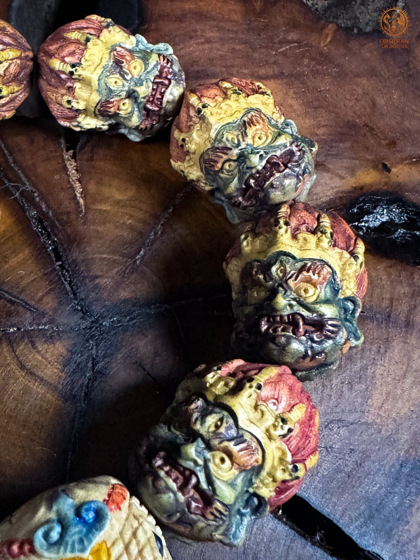 Détail de quatre têtes de Mahakala sculptées en bois de cerf, avec polychromie artisanale réalisée à partir de végétaux