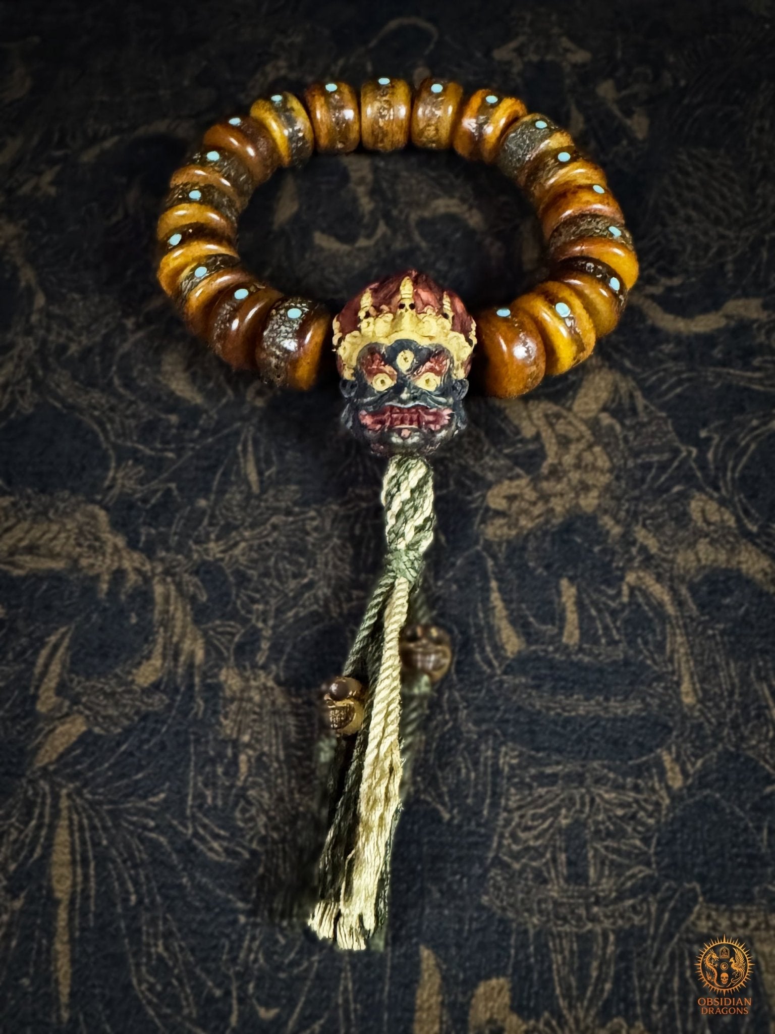 Bracelet Mahakala en os de buffle vu de face, tête polychrome en bois de cerf, turquoises naturelles du Hubei et tassel artisanal- Obsidian Dragons