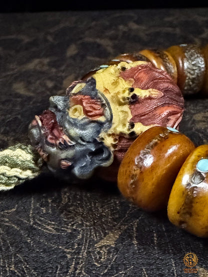 Vue latérale de la tête de Mahakala en bois de cerf entourée de perles en os de buffle incrustées de turquoise naturelle