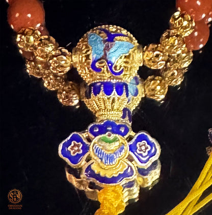 Détail de la perle Guru en argent plaqué or et émail cloisonné polychrome du bracelet mala en agate Nan Hong
