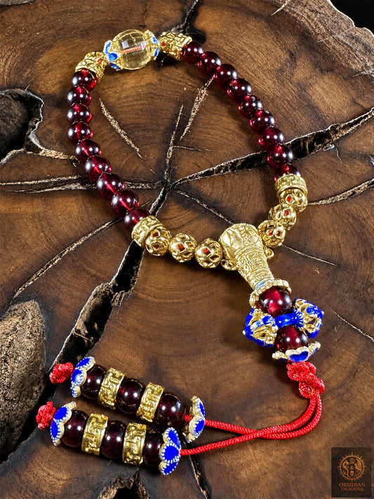 Bracelet mala en grenat et citrine Shibazi 18 perles d’Obsidian Dragons, avec dorje cloisonné bleu, bronze plaqué or et cordon rouge.