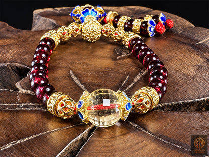 Citrine facettée du Brésil de 10 mm, encadrée de fleurs cloisonnées bleues, au premier plan du bracelet mala en grenat almandin.