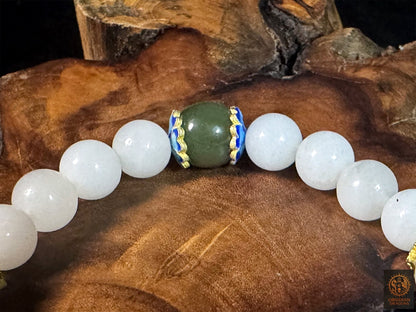 Gros plan sur la perle centrale en jade néphrite vert de Hetian, encadrée d’émaux bleus et de perles de jade blanc.