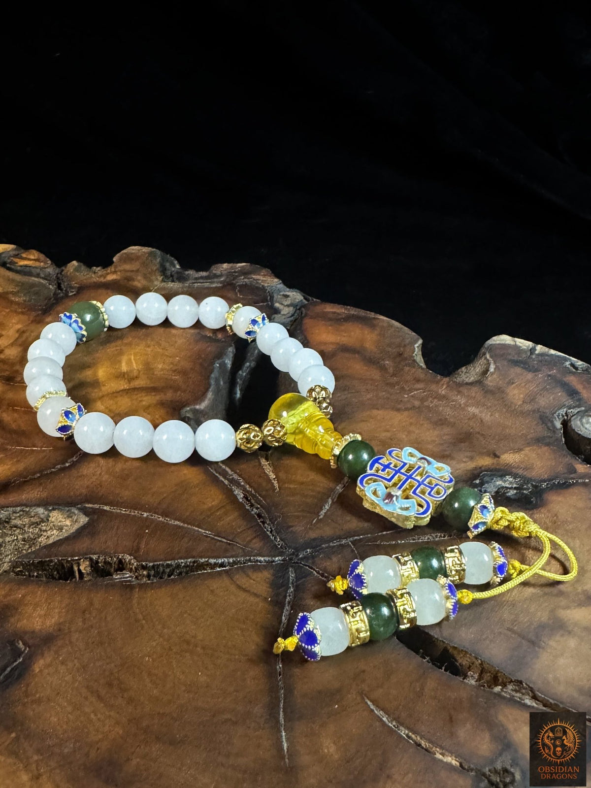 Vue de dessus du bracelet mala 18 perles en jade blanc, avec ambre de Birmanie, motif shòu et deux brins de finition décorés.