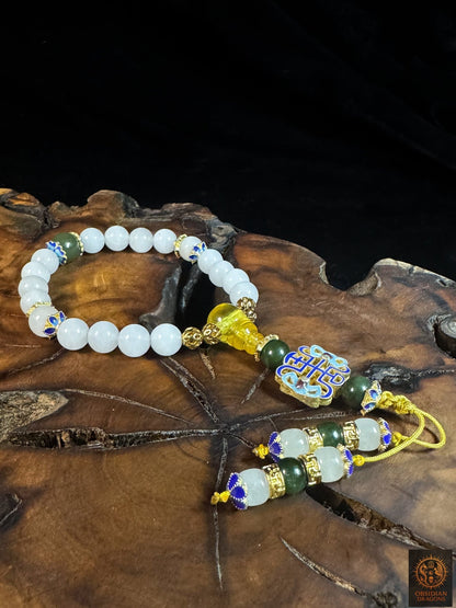 Vue de dessus du bracelet mala 18 perles en jade blanc, avec ambre de Birmanie, motif shòu et deux brins de finition décorés.