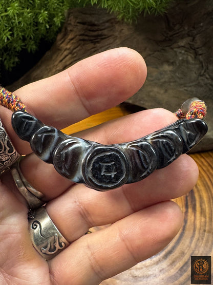 Revers du pendentif Lug Mig en agate sculptée avec motifs de pièces de monnaie gravés, amulette tibétaine artisanale.