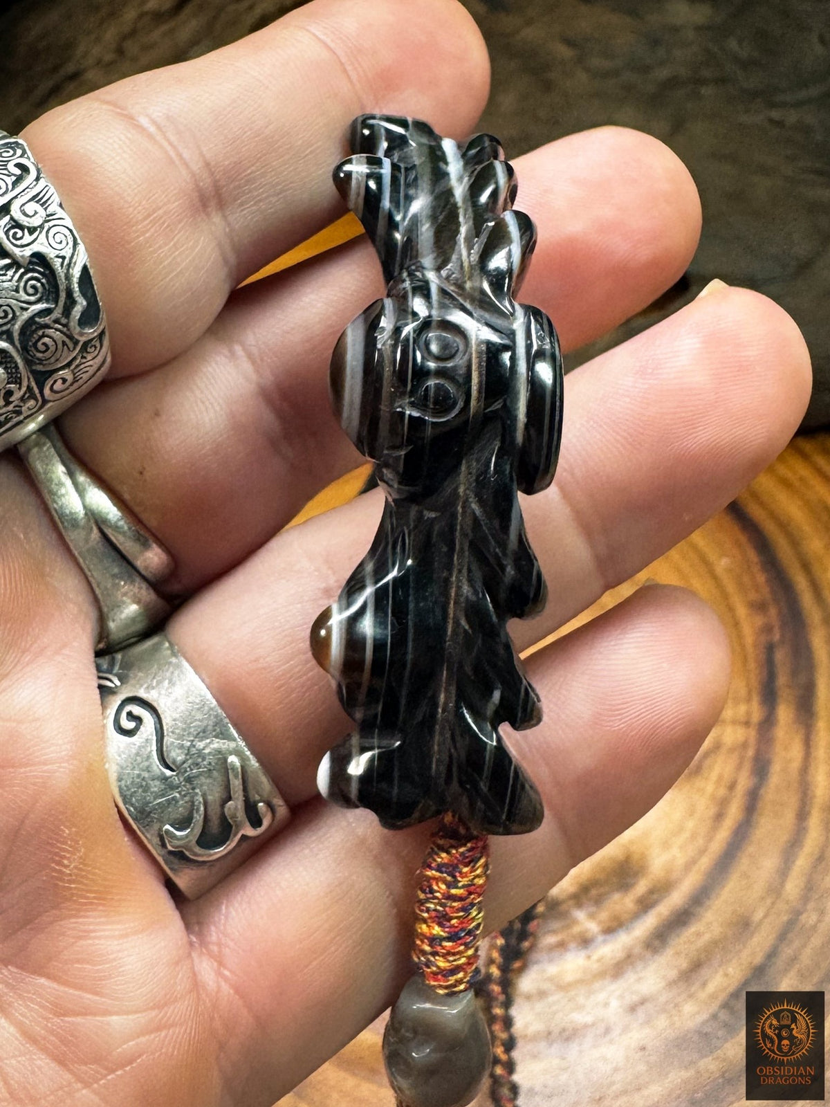Vue du dessous du pendentif Lug Mig ou Luk Mik en agate oculaire, sculpture en relief et montage sur cordon tibétain tressé.