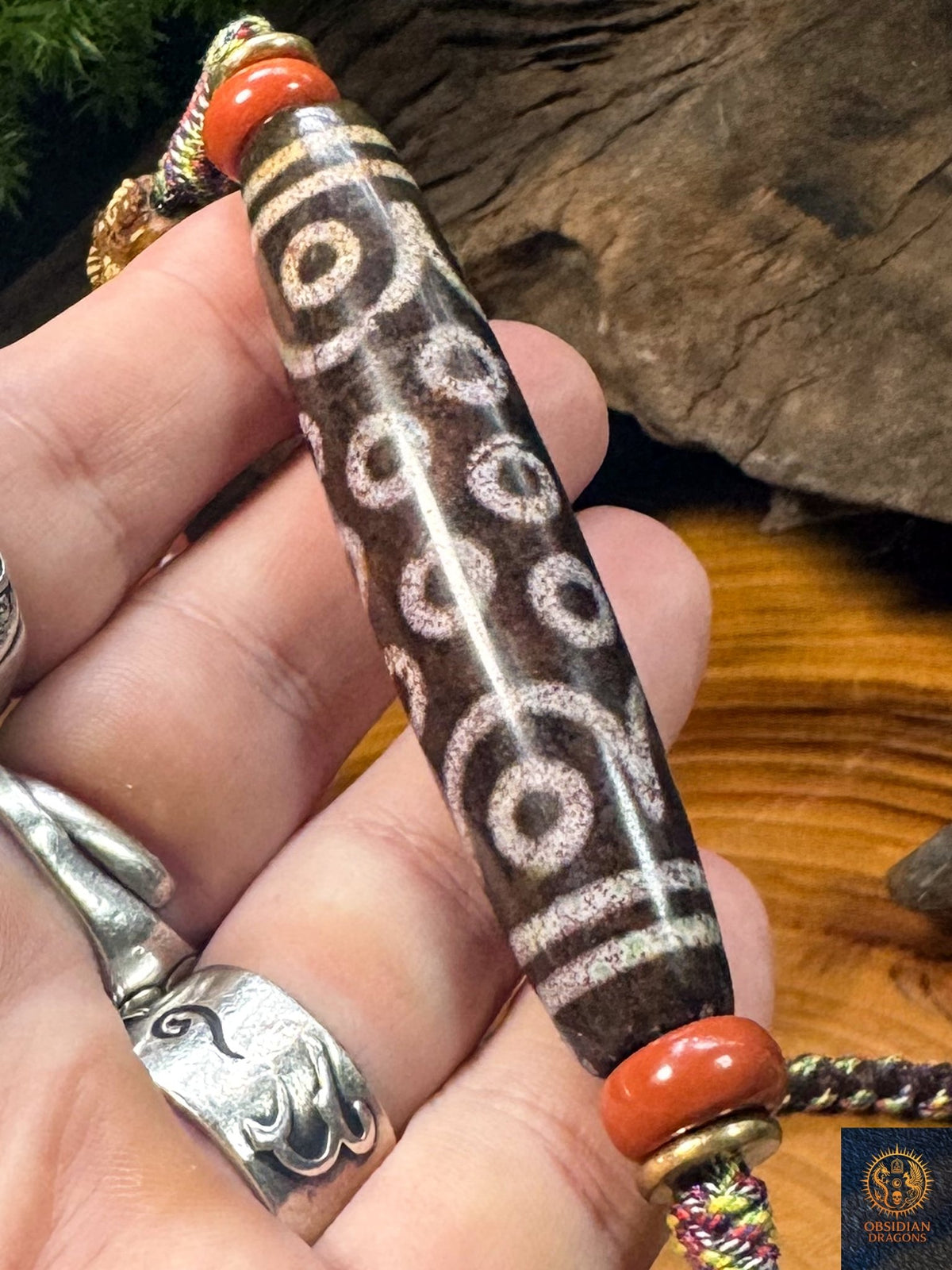 Grand DZI à 21 yeux rare en agate de 78 mm, détail de la perle tibétaine centrale du collier artisanal Obsidian Dragons
