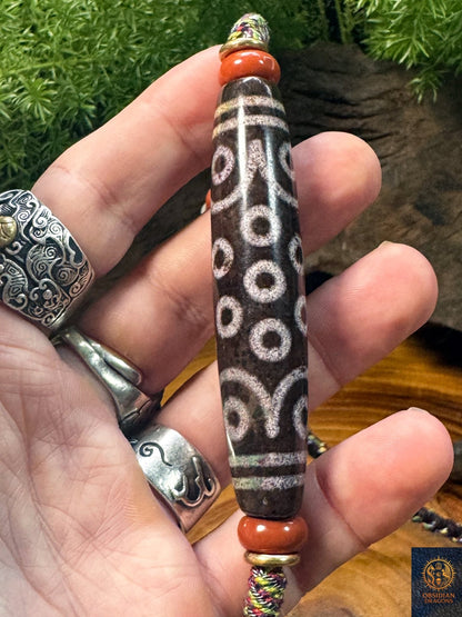 Détail du DZI à 21 yeux en agate, grande perle tibétaine rare à motifs oculaires et ponctuations rouge-brun sur collier artisanal