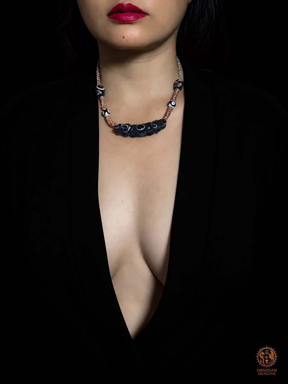 Collier œil magique tibétain Lug Mig porté par un modèle féminin, pendentif en agate oculaire noire et perles Dzi tibétaines - Obsidian Dragons