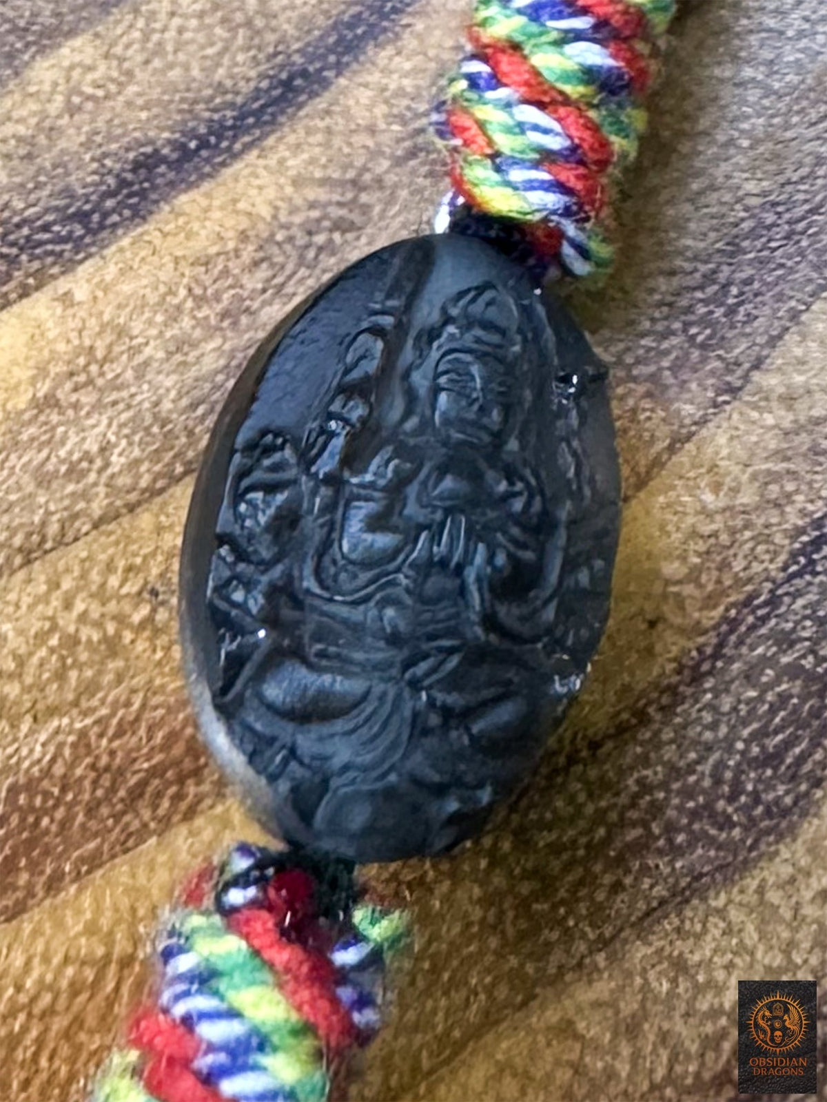 Perle en obsidienne glace translucide gravée du bodhisattva Chenrezig Mille bras, intégrée au collier tibétain Lug Mig artisanal 