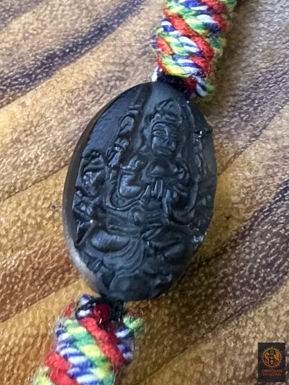 Perle en obsidienne glace translucide gravée du bodhisattva Chenrezig Mille bras, intégrée au collier tibétain Lug Mig artisanal 