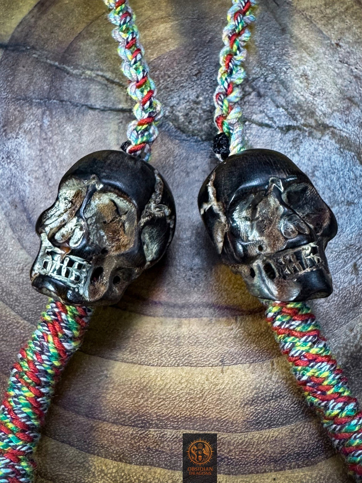 Deux crânes sculptés en corne de buffle patinée, éléments symboliques d’impermanence du collier tibétain Lug Mig artisanal