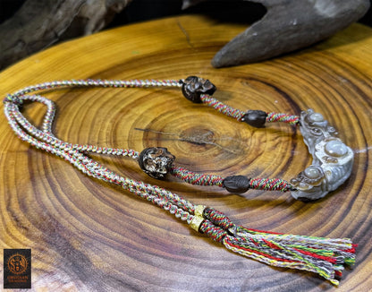 Vue en perspective du collier tibétain Lug Mig en agate, œil magique traditionnel avec obsidienne gravée, crânes en corne et tressage artisanal
