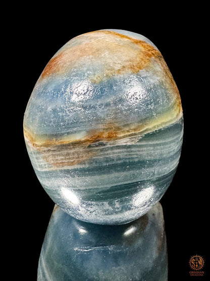 Vue arrière d’un crâne en agate bleue de Madagascar, montrant les bandes bleues, blanches et ocres de la calotte.