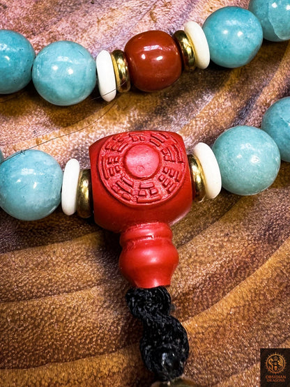 Perle Guru en cinabre gravée du bagua luopan, entourée de perles d’amazonite, d’agate Nan Hong, de cuivre et d’os de buffle