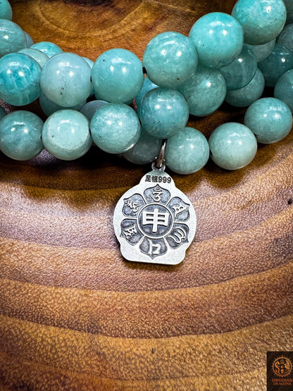 Revers du médaillon en argent 999 gravé du mantra de la compassion Om Mani Padme Hum, parmi les perles d’amazonite
