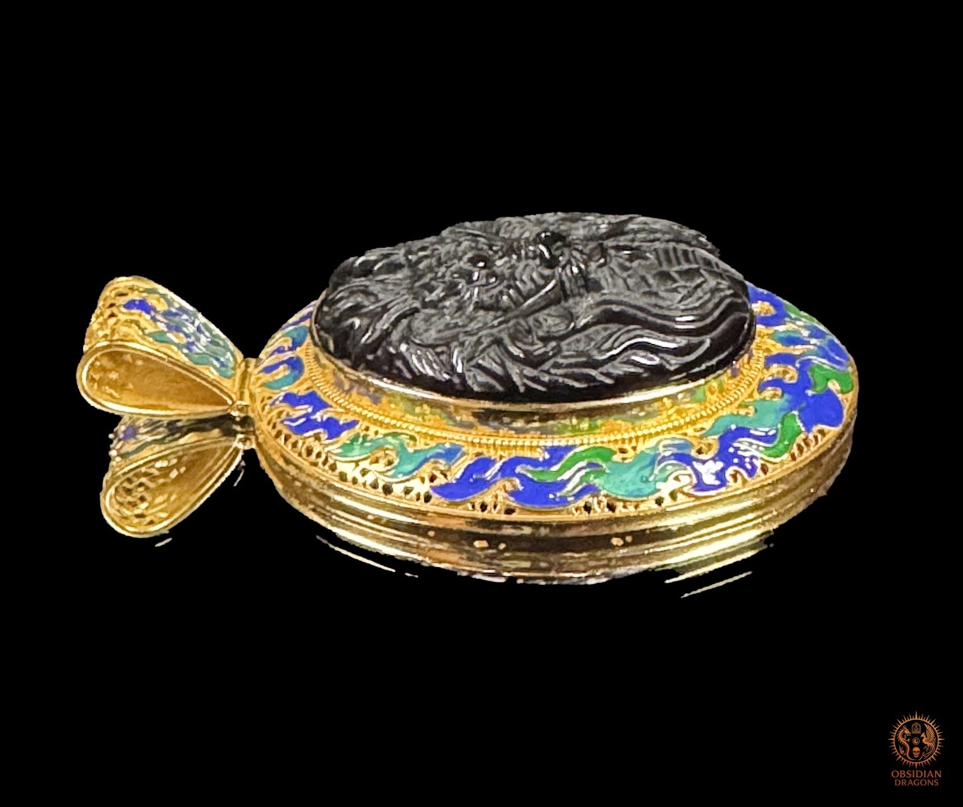 Vue de profil gauche du pendentif dragon montrant le cabochon en obsidienne sculpté en relief et la monture en vermeil