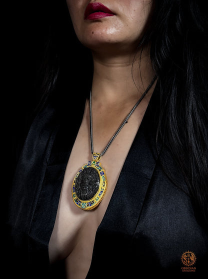 Vue portée de trois quarts du pendentif dragon en obsidienne œil céleste, avec monture en vermeil et cloisonné Leiwen