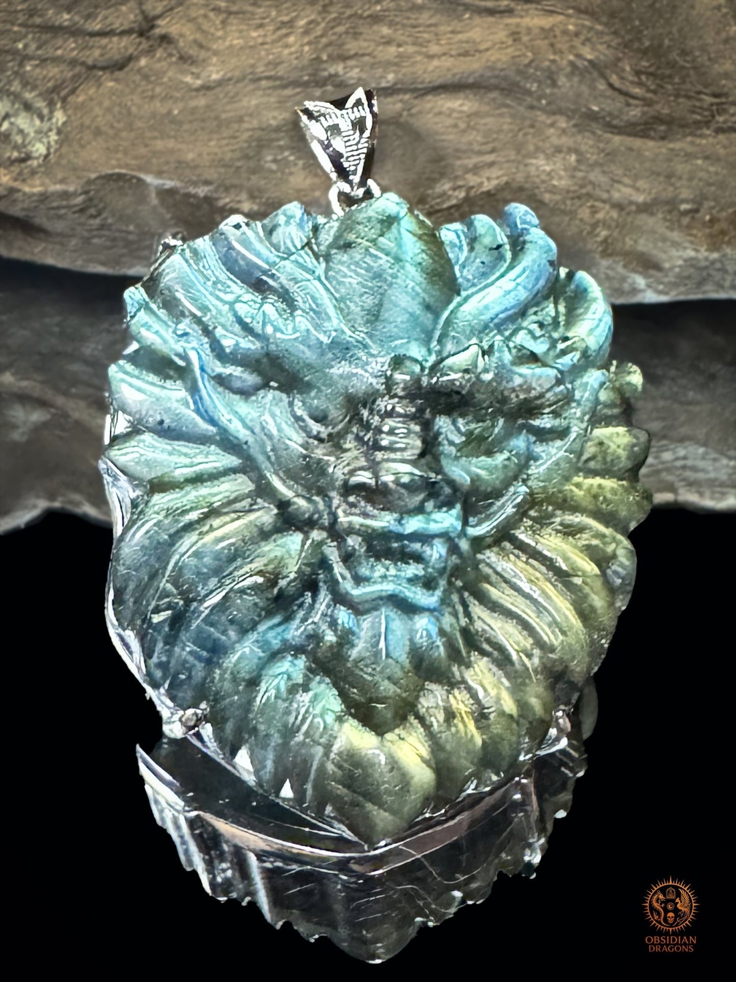 Vue frontale rapprochée du pendentif dragon en labradorite naturelle serti en argent 925, aux reflets bleus, verts et dorés - Obsidian Dragons