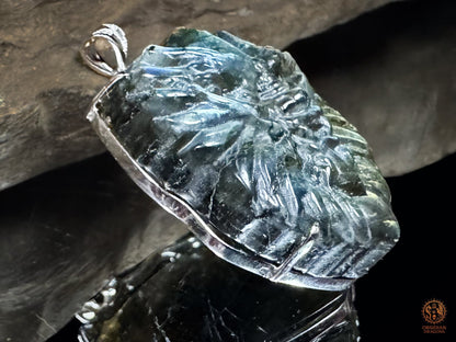 Vue de profil du pendentif tête de dragon sculptée en labradorite, montrant son relief et son sertissage artisanal en argent 925