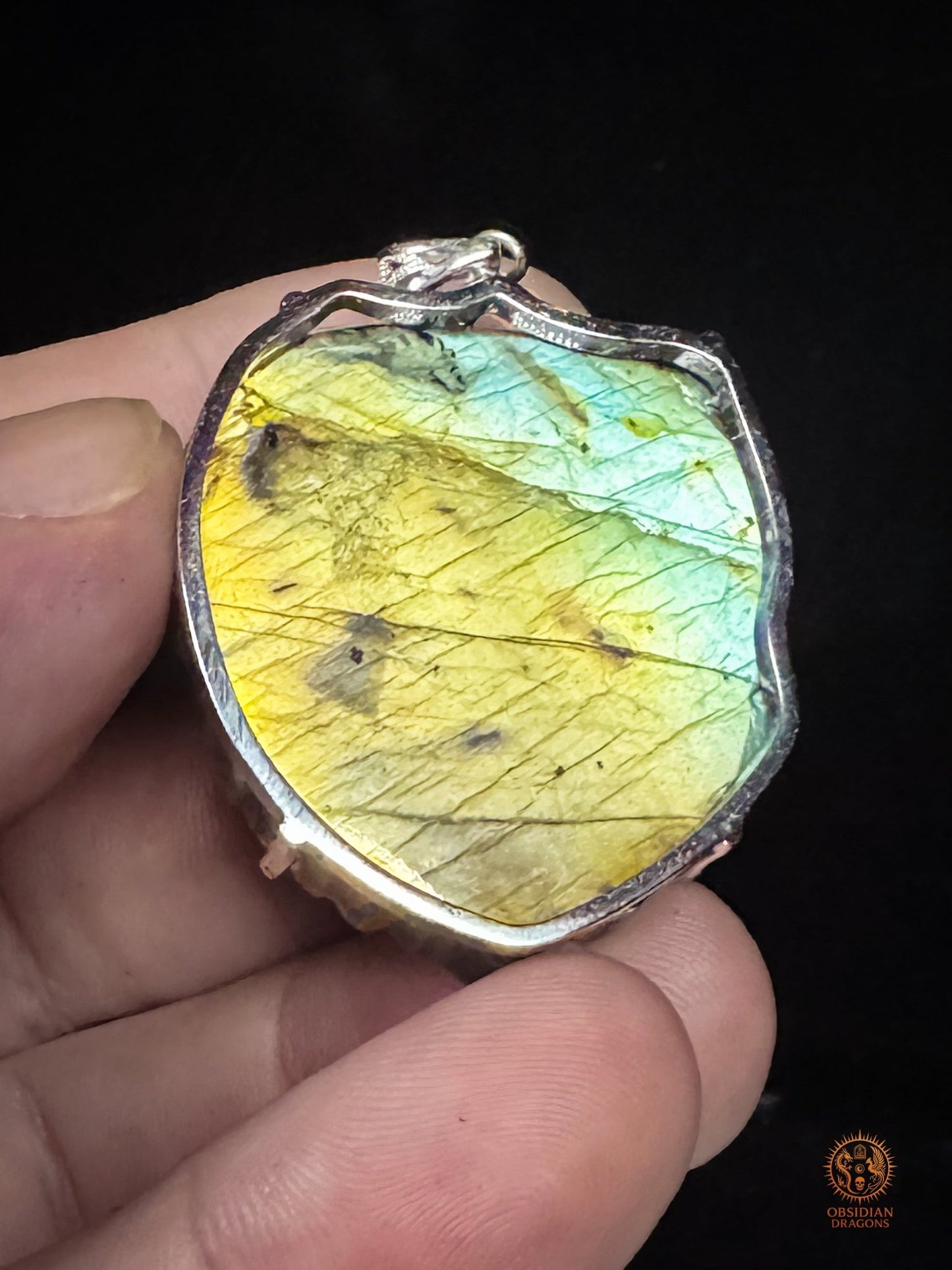Revers du pendentif dragon en labradorite avec sertissage ouvert en argent 925, révélant les reflets jaune doré, verts et turquoise