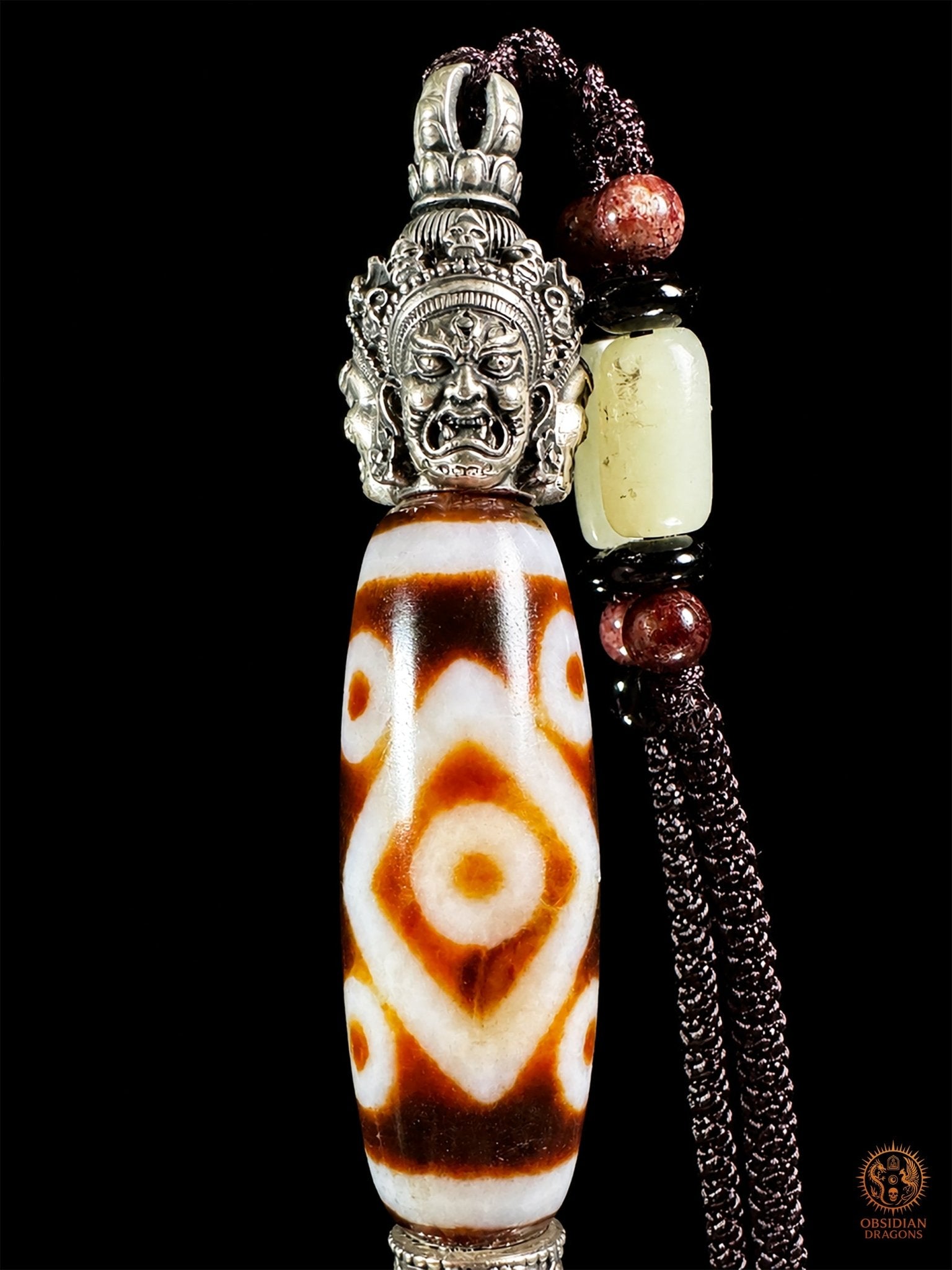 Pendentif DZI a sept yeux serti dans un phurba tibétain - obsidian dragons