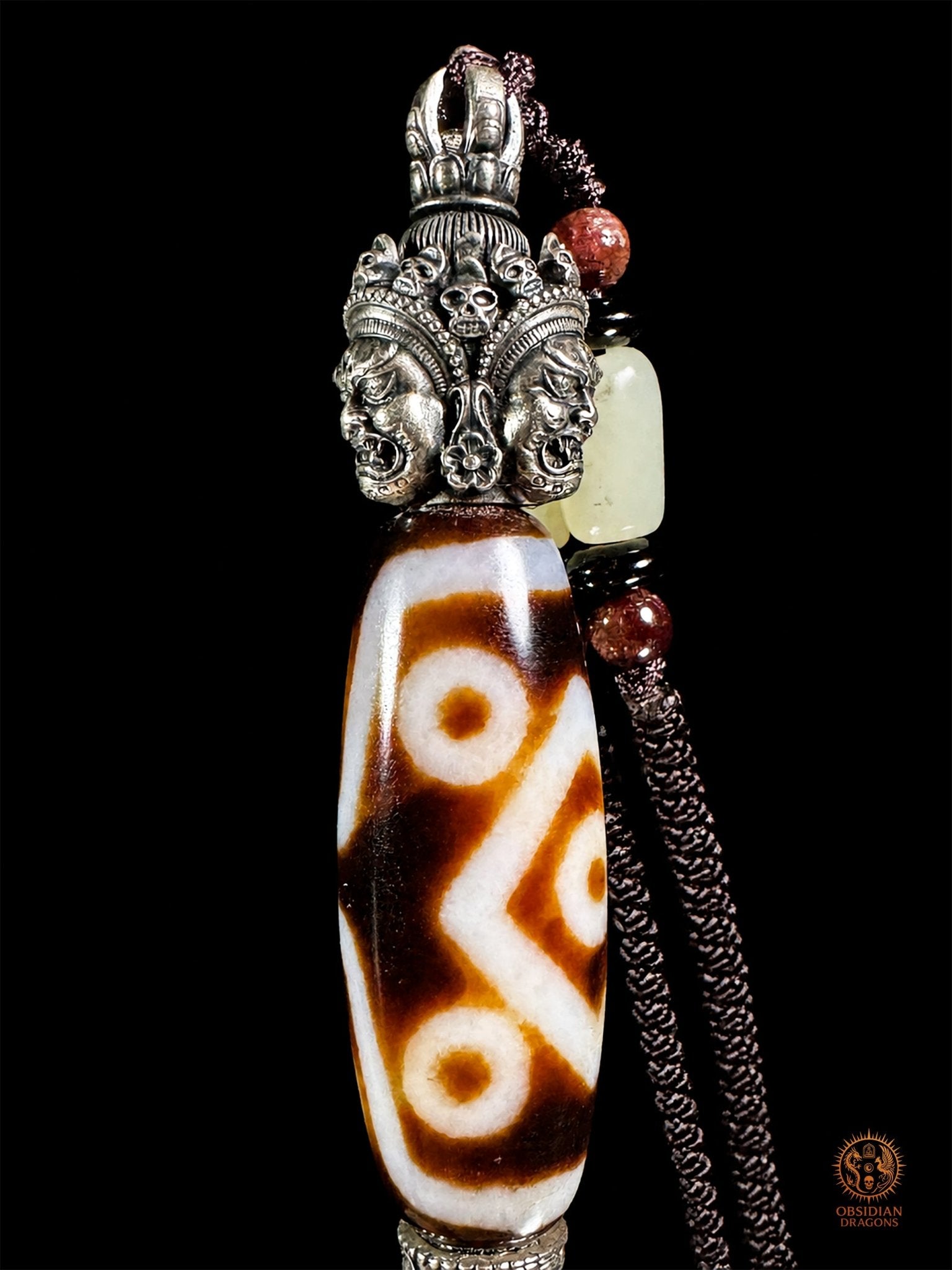 Pendentif DZI a sept yeux serti dans un phurba tibétain - obsidian dragons