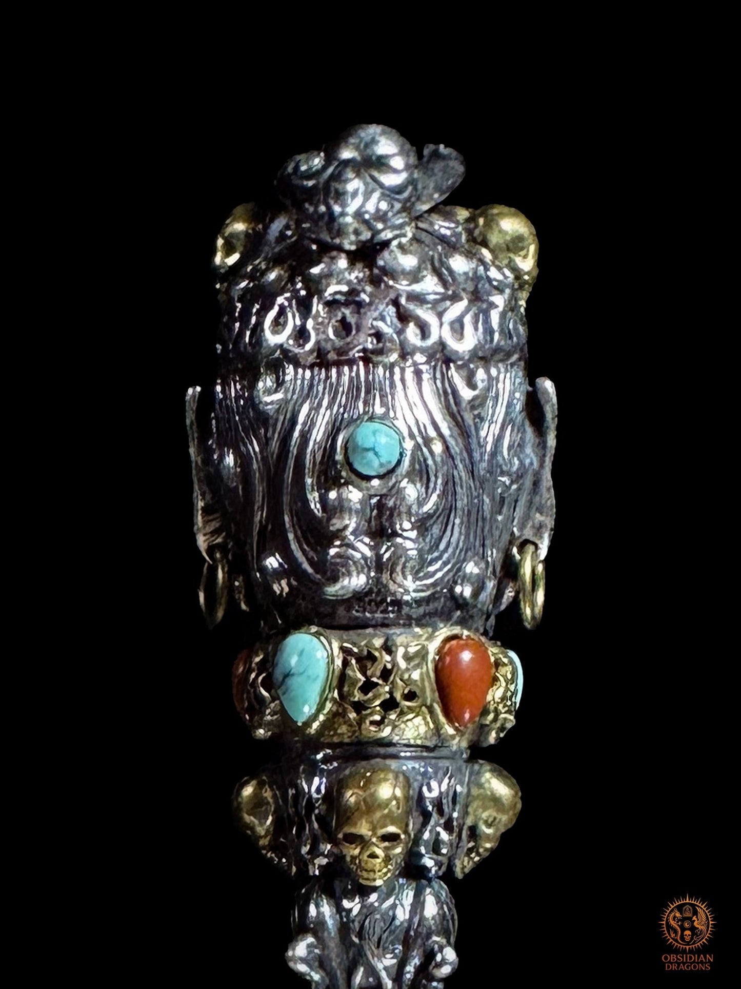 Détail du revers du pendentif Phurba, relief sculpté, cabochon de turquoise naturelle et incrustations rouges Nan Hong dans l’argent 925 et le bronze
