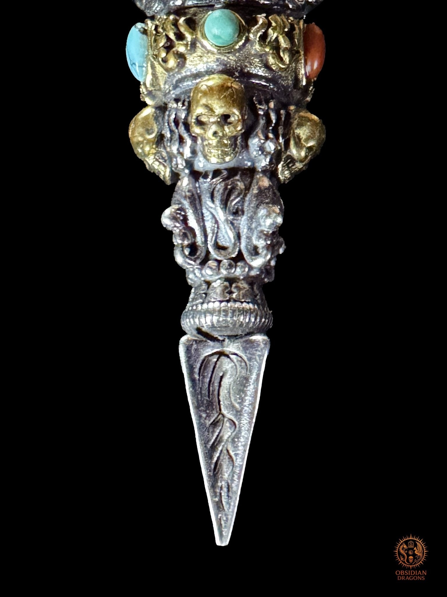 Gros plan de la partie inférieure du pendentif Phurba Mahakala, crâne en bronze, lame rituelle en argent 925, turquoise et agate Nan Hong