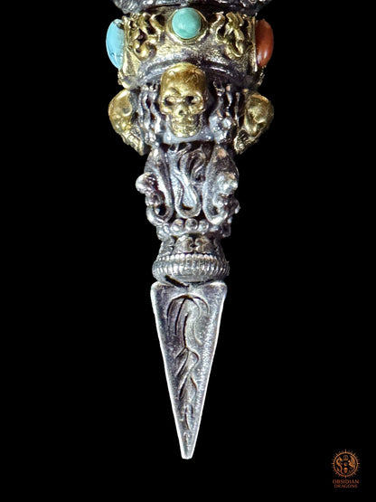 Gros plan de la partie inférieure du pendentif Phurba Mahakala, crâne en bronze, lame rituelle en argent 925, turquoise et agate Nan Hong