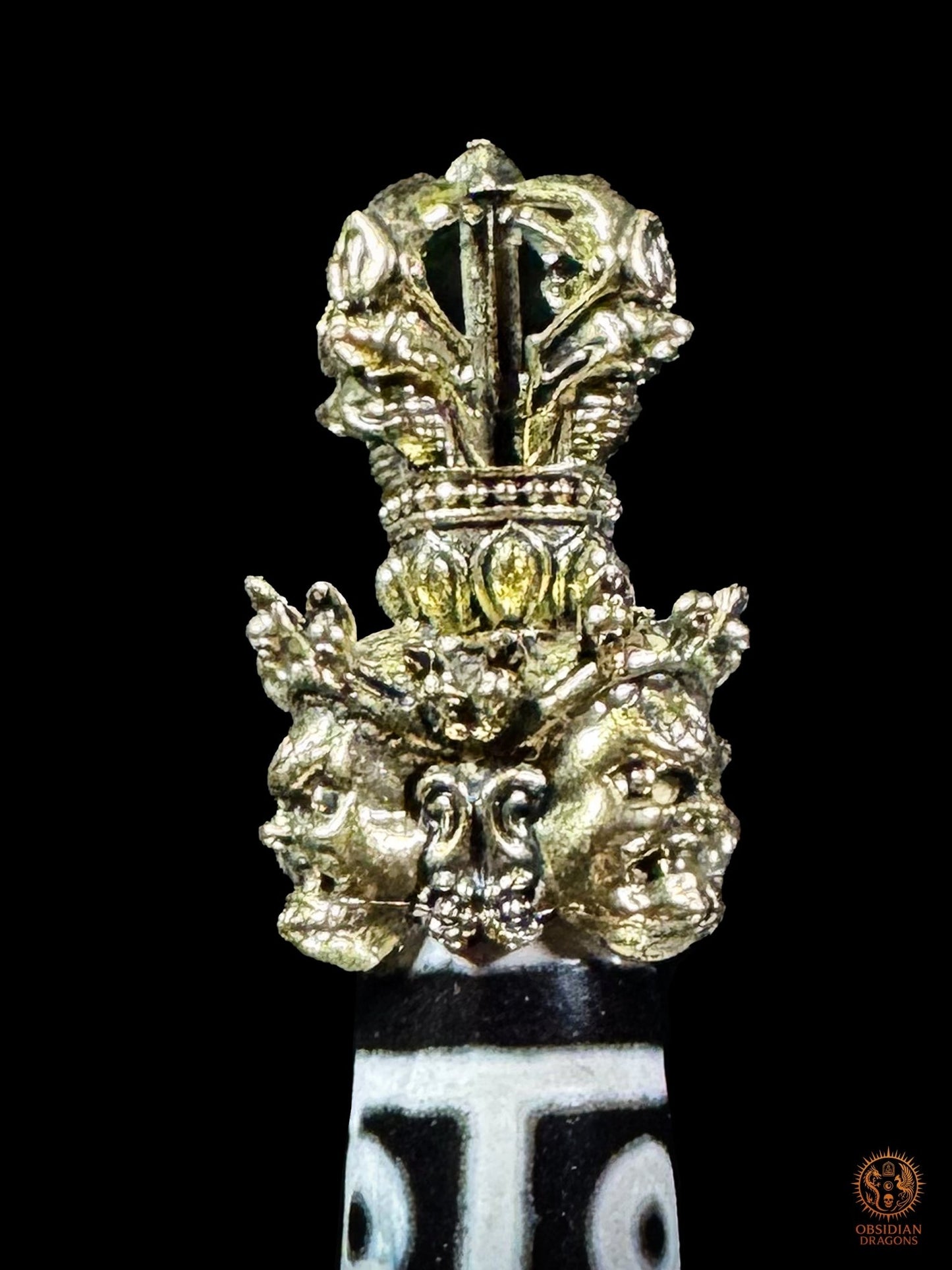 Vue arrière de la poignée en laiton du Phurba tibétain avec DZI à 9 yeux ornée de visages rituels et d’un vajra
