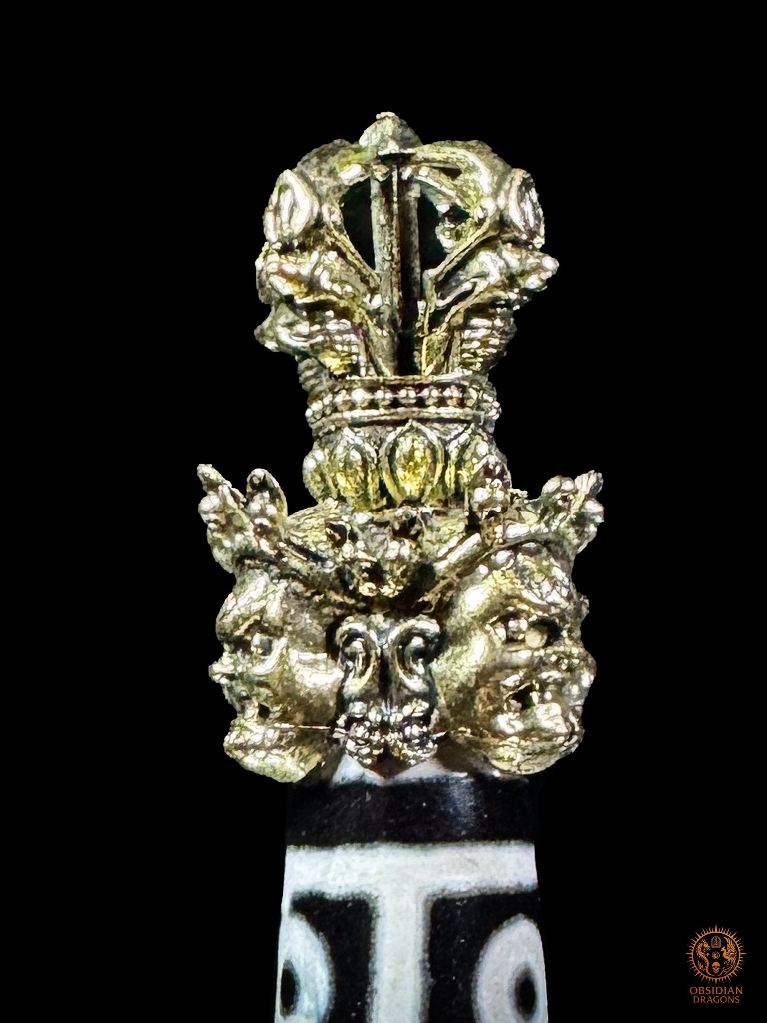 Vue arrière de la poignée en laiton du Phurba tibétain avec DZI à 9 yeux ornée de visages rituels et d’un vajra
