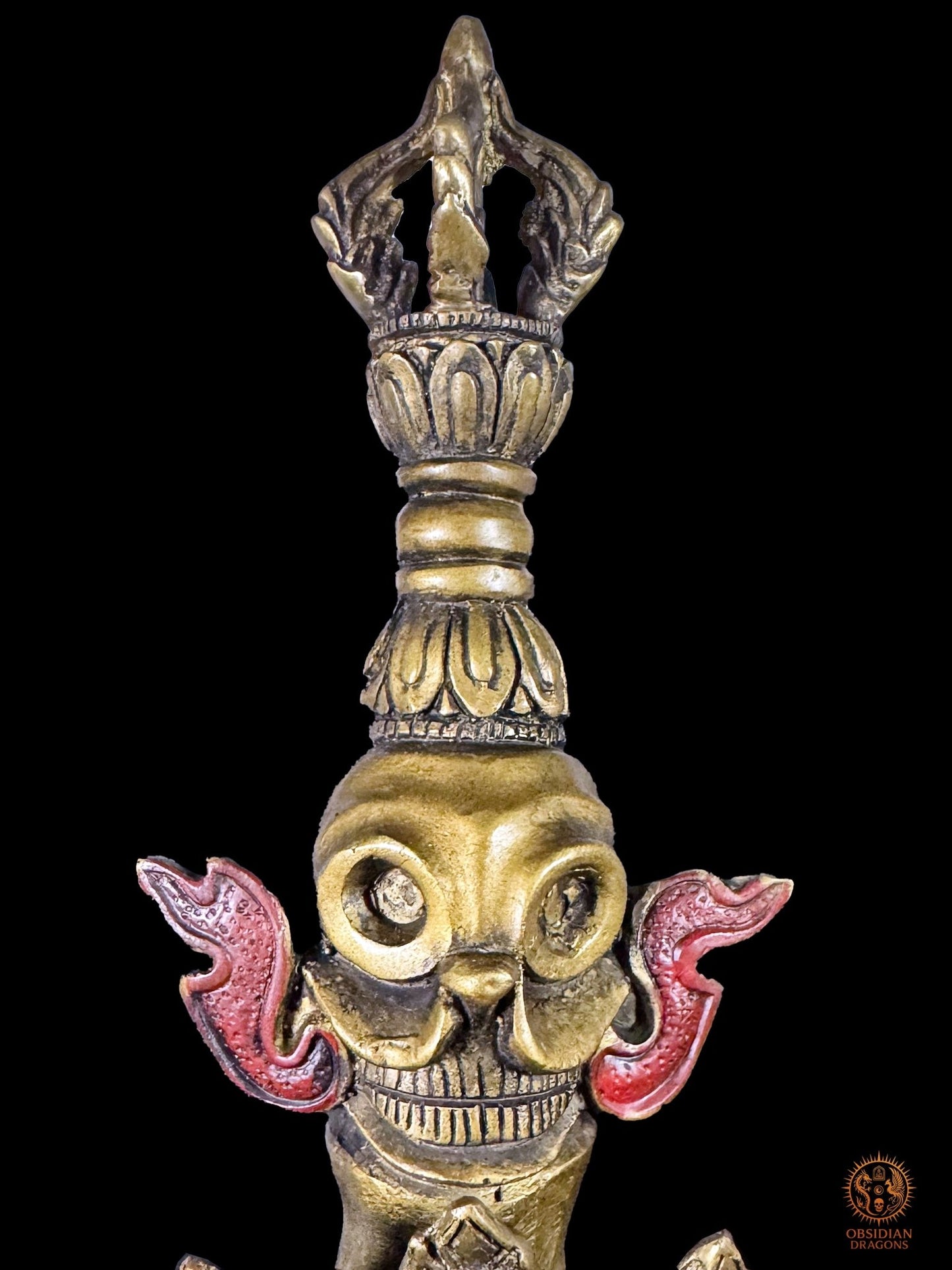 Crâne rituel et vajra sommital du phurba tibétain monumental, symboles d’impermanence et d’état adamantin dans le Vajrayana