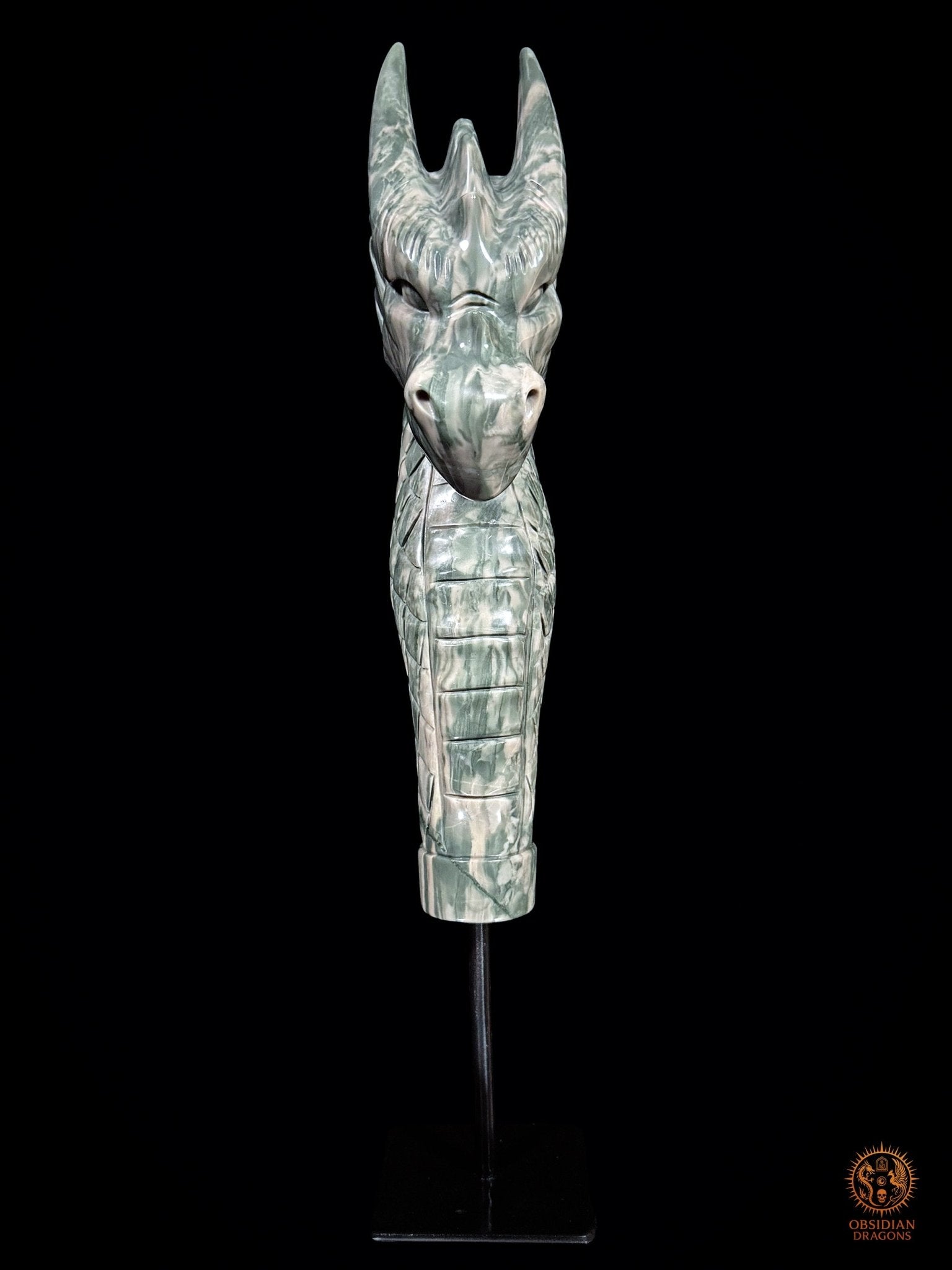 Vue frontale de la sculpture de dragon en jade des Neuf Dragons sur socle noir, avec cornes dressées et long cou couvert d’écailles