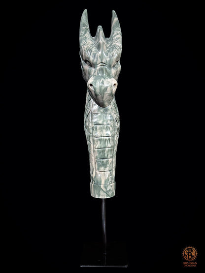 Vue frontale de la sculpture de dragon en jade des Neuf Dragons sur socle noir, avec cornes dressées et long cou couvert d’écailles