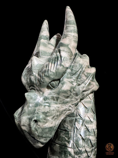 Détail du visage du dragon en jade Jiulong, avec œil profondément sculpté, cornes dressées et motifs de pierre-paysage
