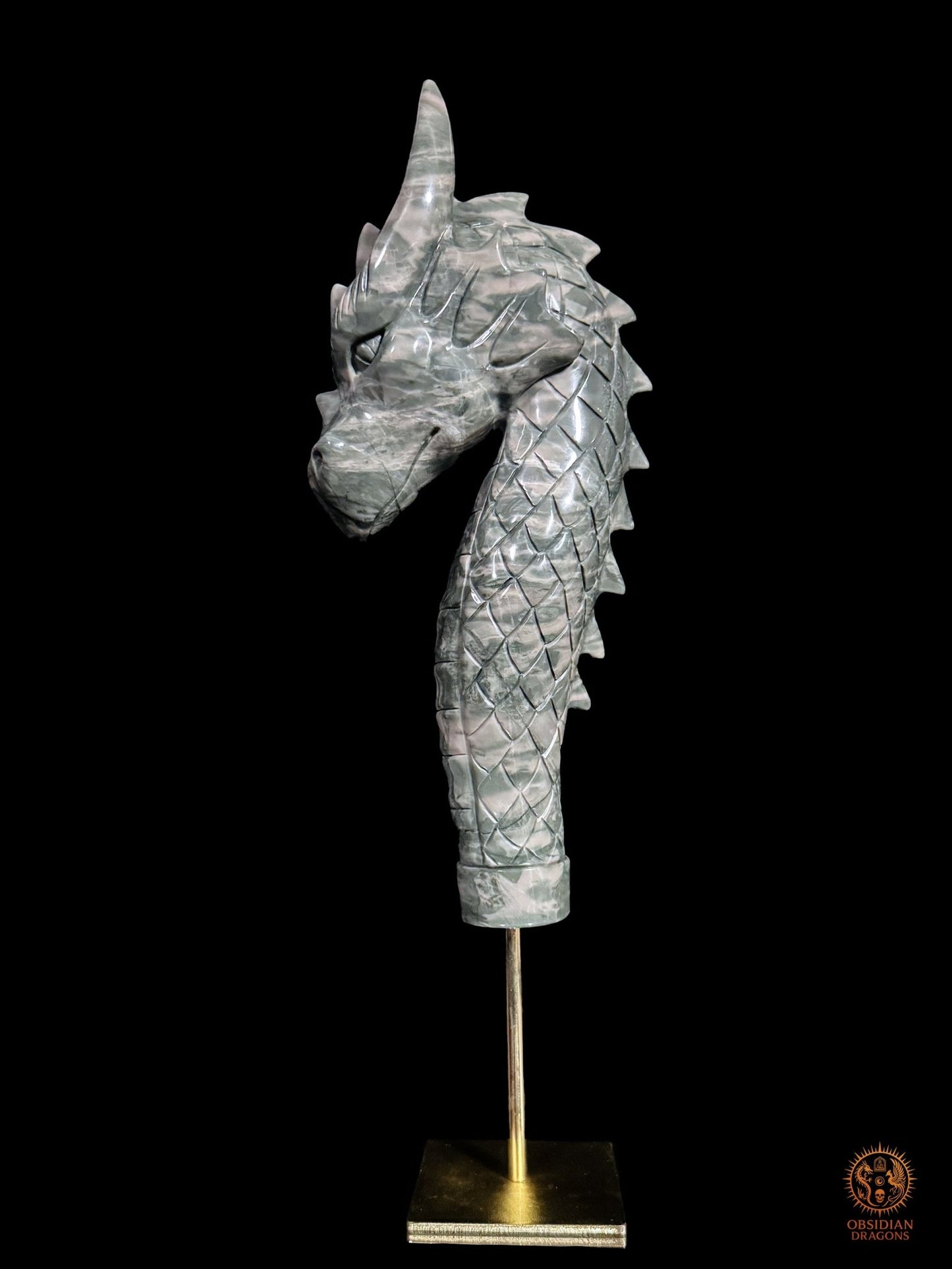 Profil gauche de la sculpture de dragon en jade des Neuf Dragons, avec écailles, crête dorsale et socle en cuivre
