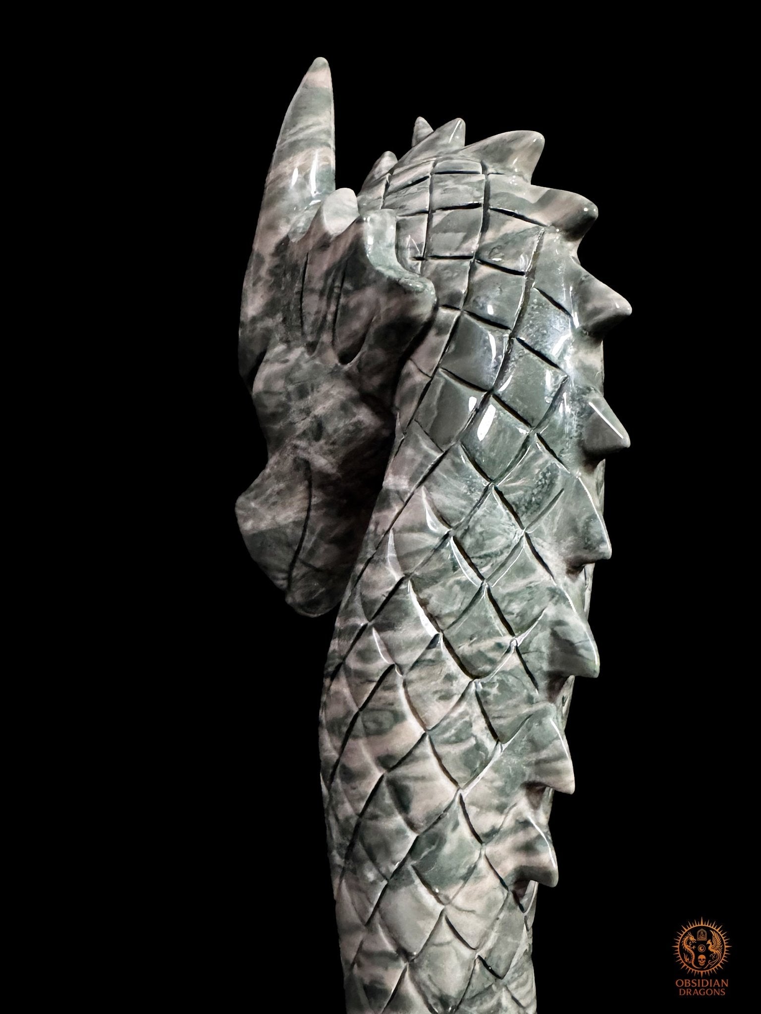 Gros plan sur la nuque et la crête du dragon en Hua’an Yu, avec écailles sculptées et veinures naturelles vertes et crème
