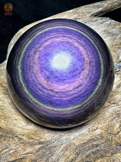 Sphère en obsidienne œil céleste Manta Huichol, large centre bleu-violet, anneaux lavande et fine bordure verte sur fond noir - Obsidian Dragons