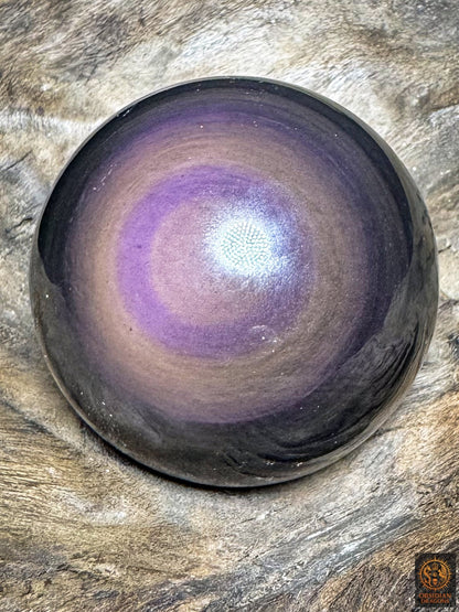 Sphère en obsidienne œil céleste, centre mauve rosé entouré d’un anneau violet et de larges couronnes aux nuances cuivrées.