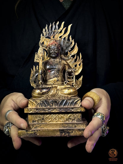 Statue d’Acala en bronze tenue entre deux mains, montrant l’échelle de Fudō Myōō assis en lotus sur son socle bouddhiste orné - Obsidian Dragons